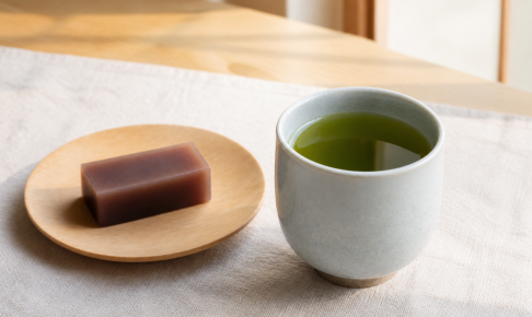 棒茶を入れた青灰色の湯のみと、木皿に添えた羊羹の説明用イメージ