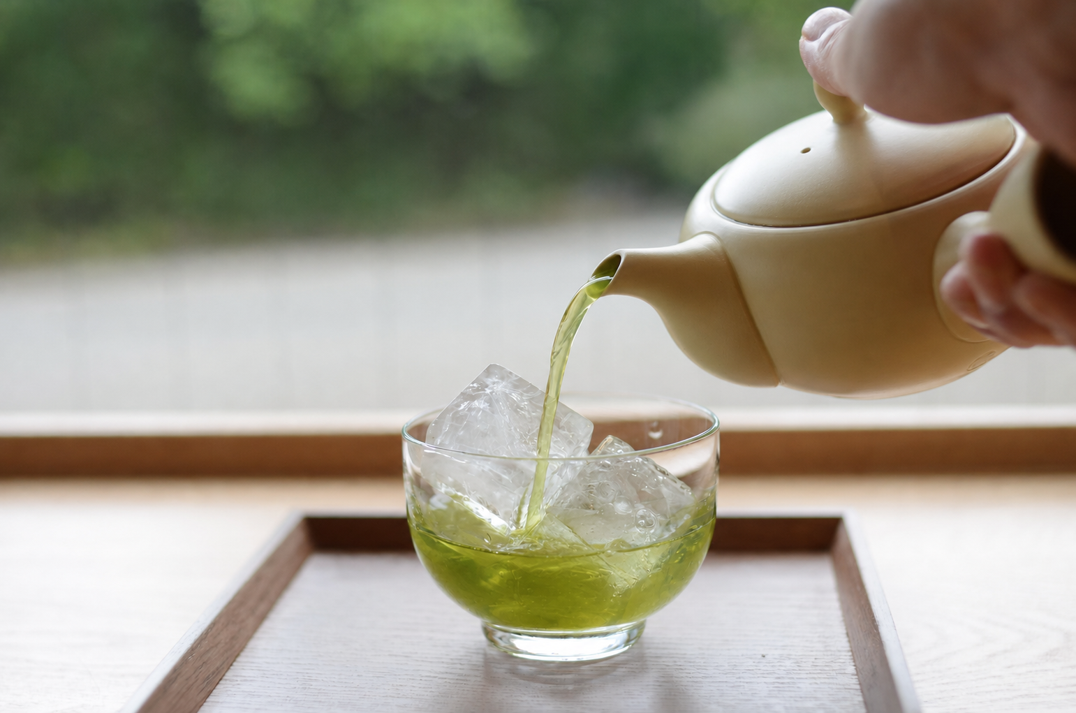 氷を入れたグラスに急須から淡い緑色の棒茶を注ぐ様子