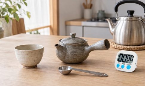 小さな急須、湯のみ、小さじ、タイマー、やかんを並べた熱湯棒茶の準備イメージ