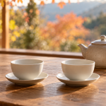 秋の光が差す木のテーブルに並べた空の白い茶杯と茶器