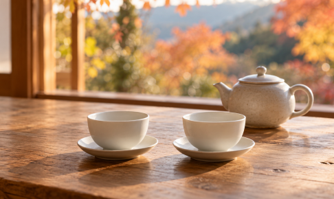 秋の光が差す木のテーブルに並べた空の白い茶杯と茶器